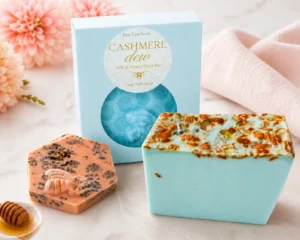 Bar of cashmere dew goat milk soap with honey and honey elixir, surrounded by a bowl of honey